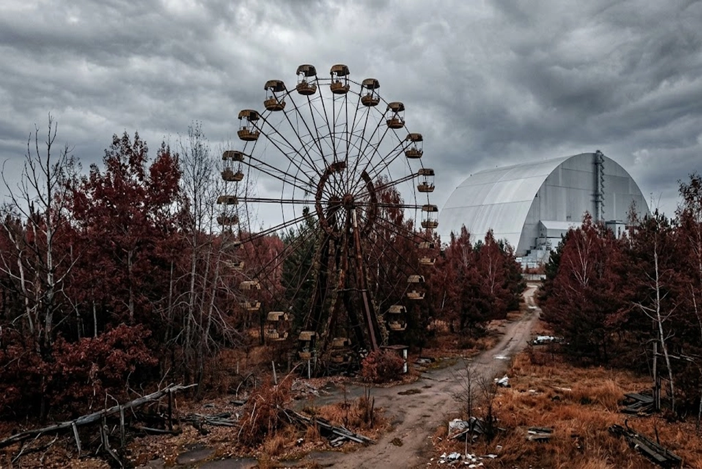 “Chernóbil datos curiosos: vista realista del Bosque Rojo con la rueda de la fortaleza abandonada y el nuevo sarcófago, mostrando la zona de exclusión.”