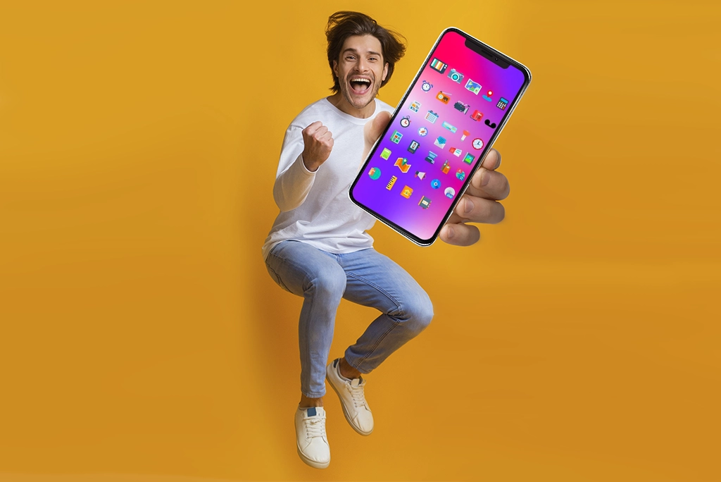 Un hombre emocionado sosteniendo un smartphone, destacando cómo estos dispositivos reúnen múltiples herramientas en un solo lugar.