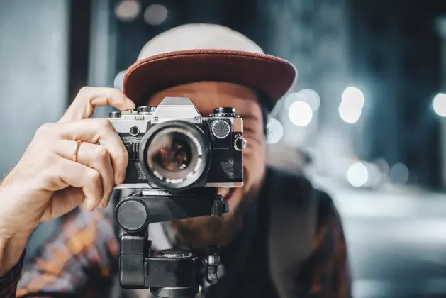Fotógrafo principiante usando una de las mejores cámaras profesionales para principiantes, capturando imágenes de alta calidad con equipo accesible.
