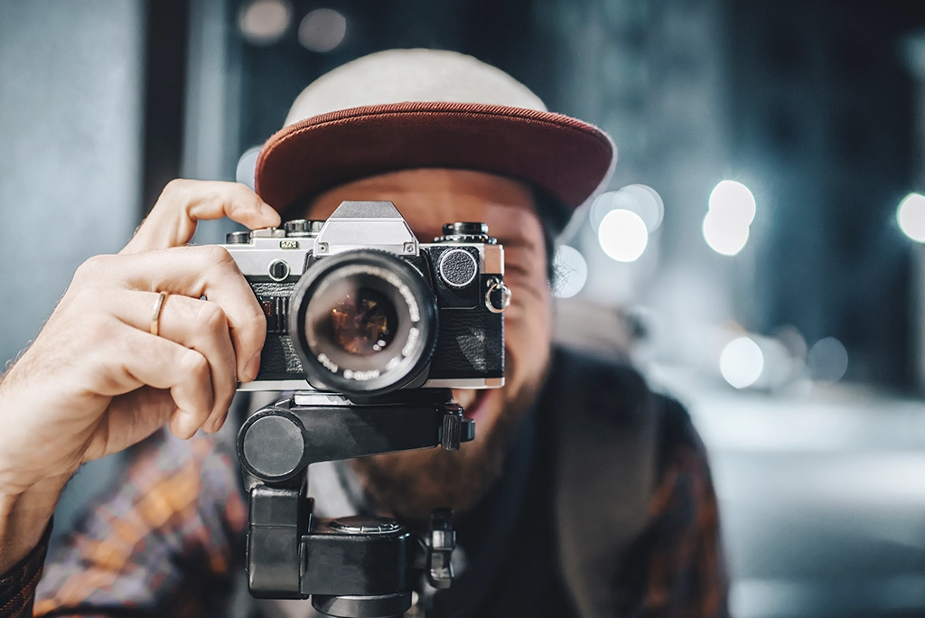 Fotógrafo principiante usando una de las mejores cámaras profesionales para principiantes, capturando imágenes de alta calidad con equipo accesible.