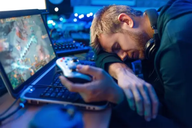 Imagen de joven agotado de jugar videojuegos, mostrando las consecuencias de su adicción