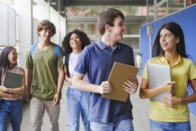 Estudiantes sonrientes en la universidad: cómo la felicidad en la etapa universitaria impacta en el éxito académico.