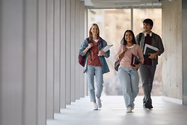 Jóvenes universitarios en su primer día de clases, riendo y conviviendo, simbolizando cómo detectar a futuros amigos en el Día Internacional de la Amistad