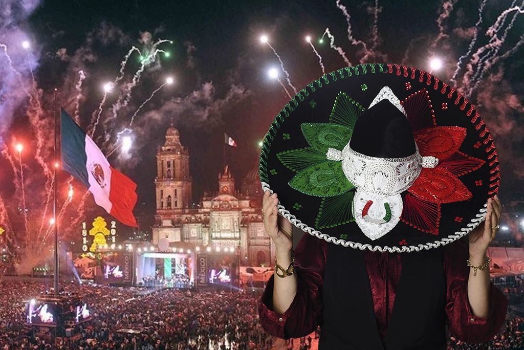 Multitud festejando la noche del 15 de septiembre con banderas mexicanas durante el Grito de Independencia