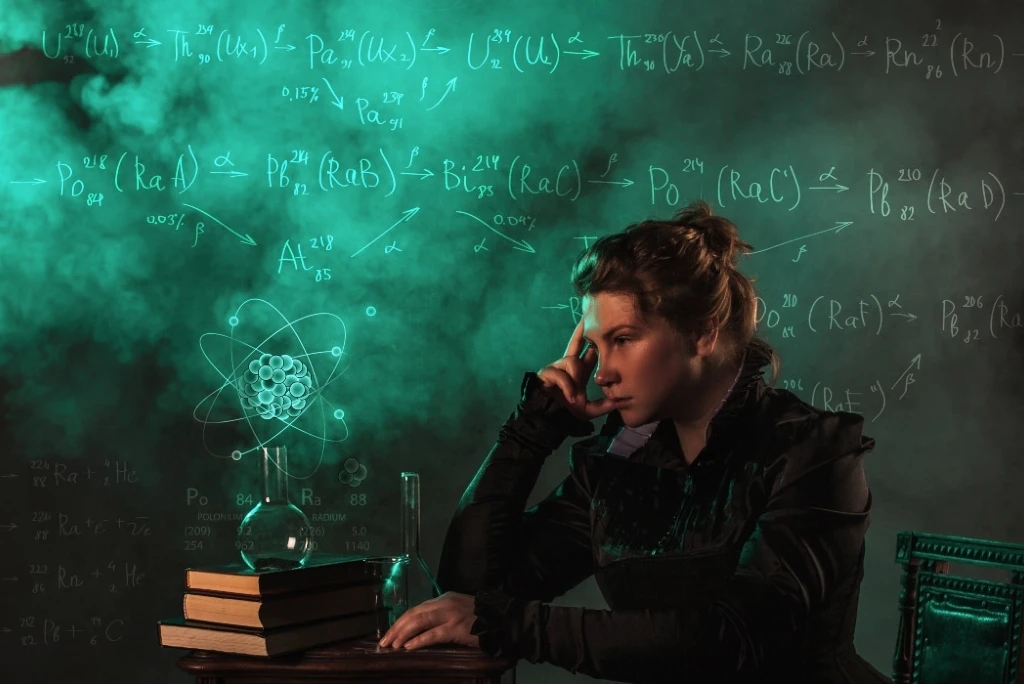 Imagen creada con IA de Marie Curie pensativa y con ecuaciones a su alrededor, siendo una de las personalidades de físicos más importantes de la historia por sus contribuciones a dicha ciencia