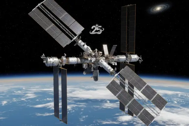 Vista exterior de la Estación Espacial Internacional orbitando la Tierra con sus paneles solares desplegados, celebrando 25 años en el espacio
