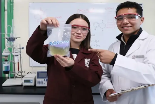 jovenes investigador del IPN sosteniendo una bolsa transparente de material hidrosoluble frente a un fondo de laboratorio, representando la innovación IPN en plásticos purificadores de agua