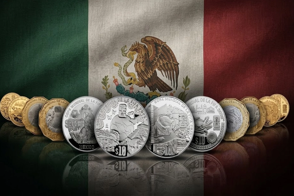 Primer plano de varias monedas conmemorativas del Mundial del Banxico sobre un fondo de pasto de cancha de fútbol, con una sombra de balón y los colores de la bandera mexicana de fondo.