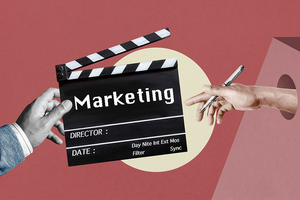 Una claqueta de cine con la palabra "Marketing" en el centro, simbolizando la relación entre películas y estrategias de marketing, mientras una mano sostiene un bolígrafo, lista para escribir.