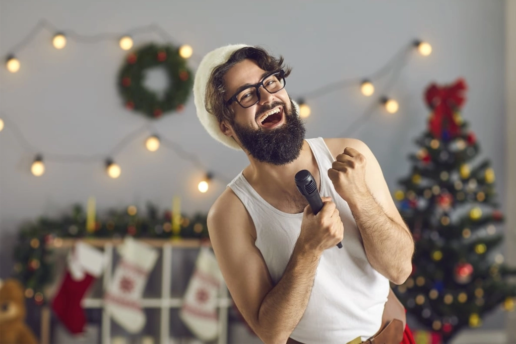joven con disfraz de santa claus y con micrófono en mano cantando canciones de navidad de playlist en Spotify