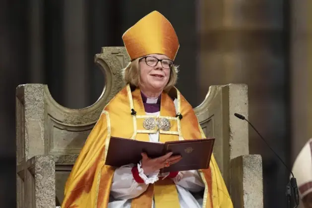 Foto de Sarah Mullally sonriente con vestiduras litúrgicas tradicionales dentro de la imponente Catedral de Canterbury, que explica qué es la Iglesia Anglicana al mostrar a su primera arzobispa mujer en el centro histórico del anglicanismo.